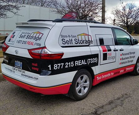 A van featuring the self storage logo, parked on the street